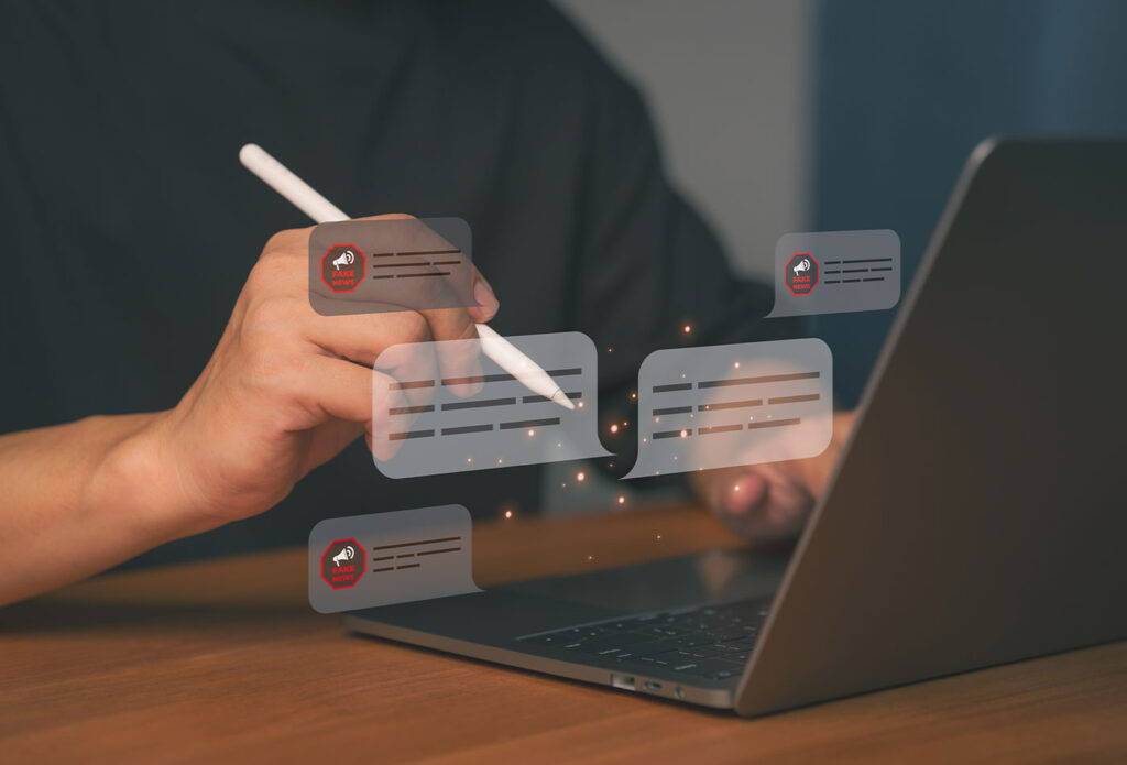 Persona contrastando información en portátil